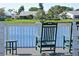 Two green rocking chairs on a deck overlooking a lake at 4799 Independence Dr, Bradenton, FL 34210