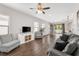 Open living room with hardwood floors, gray sofas, and a view into the kitchen at 491 Casalino Dr, Nokomis, FL 34275