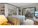 Bedroom with a queen bed, built-in shelving, and sliding glass doors to balcony at 6114 43Rd W St # 104E, Bradenton, FL 34210
