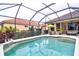 Refreshing pool area with screened enclosure, manicured landscaping, and cozy seating, perfect for outdoor enjoyment at 6611 Pinefeather Ct, Bradenton, FL 34203