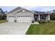 Two-car garage, covered porch, and landscaped lawn at 6614 162Nd E Pl, Parrish, FL 34219