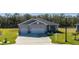 Single-story house with three-car garage and landscaped yard at 6614 162Nd E Pl, Parrish, FL 34219