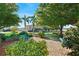 Well-manicured community grounds with lush landscaping, benches, and a welcoming path, showcasing a serene environment at 703 Corsica Ct, Bradenton, FL 34207