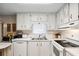 Well-maintained kitchen with bright white cabinets, appliances, and a double sink at 703 Corsica Ct, Bradenton, FL 34207