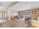 Inviting living room featuring carpet, wood paneling, and bright windows at 703 Corsica Ct, Bradenton, FL 34207