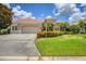 Single-Gathering home exterior featuring a tile roof, landscaping, and two-car garage at 8219 Championship Ct, Lakewood Ranch, FL 34202