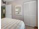 Guest bedroom with striped bedding and mirrored closet doors at 8466 Maureen Ave, North Port, FL 34287