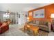 Bright living room with orange walls, comfy couch, and tiled floor at 8466 Maureen Ave, North Port, FL 34287