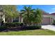 House exterior showcasing landscaping and palm trees in the front yard at 8773 Stone Harbour Loop, Bradenton, FL 34212