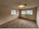 Simple bedroom with wall-to-wall carpet and two large windows at 975 S Tuttle Ave, Sarasota, FL 34237