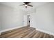 Bedroom with wood-look floors, ceiling fan, and access to another room at 1010 E Lake Ave, Tampa, FL 33605