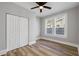 Bedroom with ceiling fan, wood-look floors, and double door closet at 1010 E Lake Ave, Tampa, FL 33605