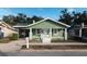 Charming green house with a porch and well-maintained lawn at 1010 E Lake Ave, Tampa, FL 33605