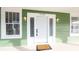 Charming green house with a welcoming front porch and white door at 1010 E Lake Ave, Tampa, FL 33605