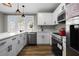 Modern white kitchen with stainless steel appliances and quartz countertops at 1010 E Lake Ave, Tampa, FL 33605