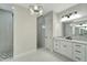 Elegant bathroom with double vanity, geometric floor and shower tile, and chandelier at 10508 Mcalester Cir, Port Charlotte, FL 33981