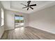 Bedroom with wood-look floors, sliding glass doors opening to a pool view at 10508 Mcalester Cir, Port Charlotte, FL 33981