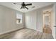 Well-lit bedroom with wood-look floors, ceiling fan, and access to hallway at 10508 Mcalester Cir, Port Charlotte, FL 33981