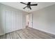 Bedroom with wood-look floors, ceiling fan, and spacious closet at 10508 Mcalester Cir, Port Charlotte, FL 33981