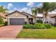 Single-story home with a two-car garage and landscaped yard at 11241 Sandhill Preserve Dr, Sarasota, FL 34238