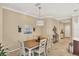 Bright dining room with wooden table and chairs, stylish chandelier, and access to kitchen at 11808 Sawgrass Lake Ter, Bradenton, FL 34211