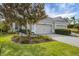 House exterior featuring a two-car garage, manicured landscaping, and a paved driveway at 11808 Sawgrass Lake Ter, Bradenton, FL 34211