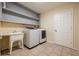 Bright laundry room, washer, dryer, utility sink, and built-in shelving at 1313 Harbor Blvd, Port Charlotte, FL 33952