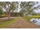 Peaceful backyard with pond view, lush landscaping, and mature trees at 135 N Creek Ln, Osprey, FL 34229