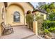 Inviting entryway with a brick patio, wooden bench, and lush greenery at 135 N Creek Ln, Osprey, FL 34229