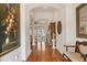 Bright hallway with hardwood floors, artwork, and views into living areas at 135 N Creek Ln, Osprey, FL 34229