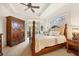 Spacious main bedroom with a large bed, wood armoire, and window seat at 135 N Creek Ln, Osprey, FL 34229