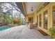 Relaxing screened-in pool area with brick pavers and wicker furniture at 135 N Creek Ln, Osprey, FL 34229