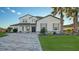 Two-story home with gray accents, paver driveway, and palm trees at 15009 18Th E Run, Parrish, FL 34219