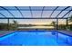 Blue illuminated pool at dusk, screened enclosure at 15009 18Th E Run, Parrish, FL 34219