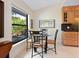 Bright breakfast nook featuring a glass table, stylish black chairs, and a view of the outdoor foliage at 1666 Pintail Way # 9, Sarasota, FL 34231