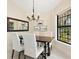 Elegant dining room with dark wood table, white upholstered chairs, and stylish chandelier at 1666 Pintail Way # 9, Sarasota, FL 34231