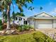 Attractive one-story home featuring a two-car garage, lush landscaping, and well-maintained lawn at 1666 Pintail Way # 9, Sarasota, FL 34231