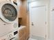 Efficient laundry area features modern, stacked washer and dryer units and custom wooden cabinetry at 1666 Pintail Way # 9, Sarasota, FL 34231