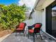 Cozy patio seating area with two wicker chairs, complete with orange cushions, for relaxation at 1666 Pintail Way # 9, Sarasota, FL 34231