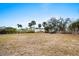 Empty lot with dry grass and some trees at 1956 Massachusetts Ave, Englewood, FL 34224