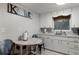 Small kitchen with white cabinets and a round wooden table at 1956 Massachusetts Ave, Englewood, FL 34224