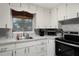 White kitchen with stainless steel appliances and gray countertops at 1956 Massachusetts Ave, Englewood, FL 34224