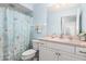 Clean bathroom, light blue walls, white vanity, and shower with curtain at 200 Mirabella Cir # 201, Venice, FL 34292