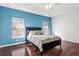 Bedroom with blue accent wall and dark wood floors at 200 Mirabella Cir # 201, Venice, FL 34292