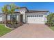 One-story home with white garage door, paver driveway, and tropical landscaping at 2114 5Th E St, Palmetto, FL 34221