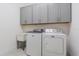 Bright laundry room with washer, dryer, and upper cabinets at 2114 5Th E St, Palmetto, FL 34221