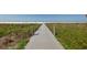 Wooden walkway leading to beach with dune vegetation at 2424 Post Rd, Sarasota, FL 34231