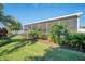 Relaxing screened patio area with tropical landscaping and lighting at 2424 Post Rd, Sarasota, FL 34231