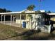 Side view of a single story home with carport, lawn and palm trees at 2710 Hibiscus St, Sarasota, FL 34239