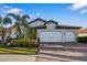 Two-story house with white double garage doors and landscaping at 275 Toscavilla Blvd, Nokomis, FL 34275